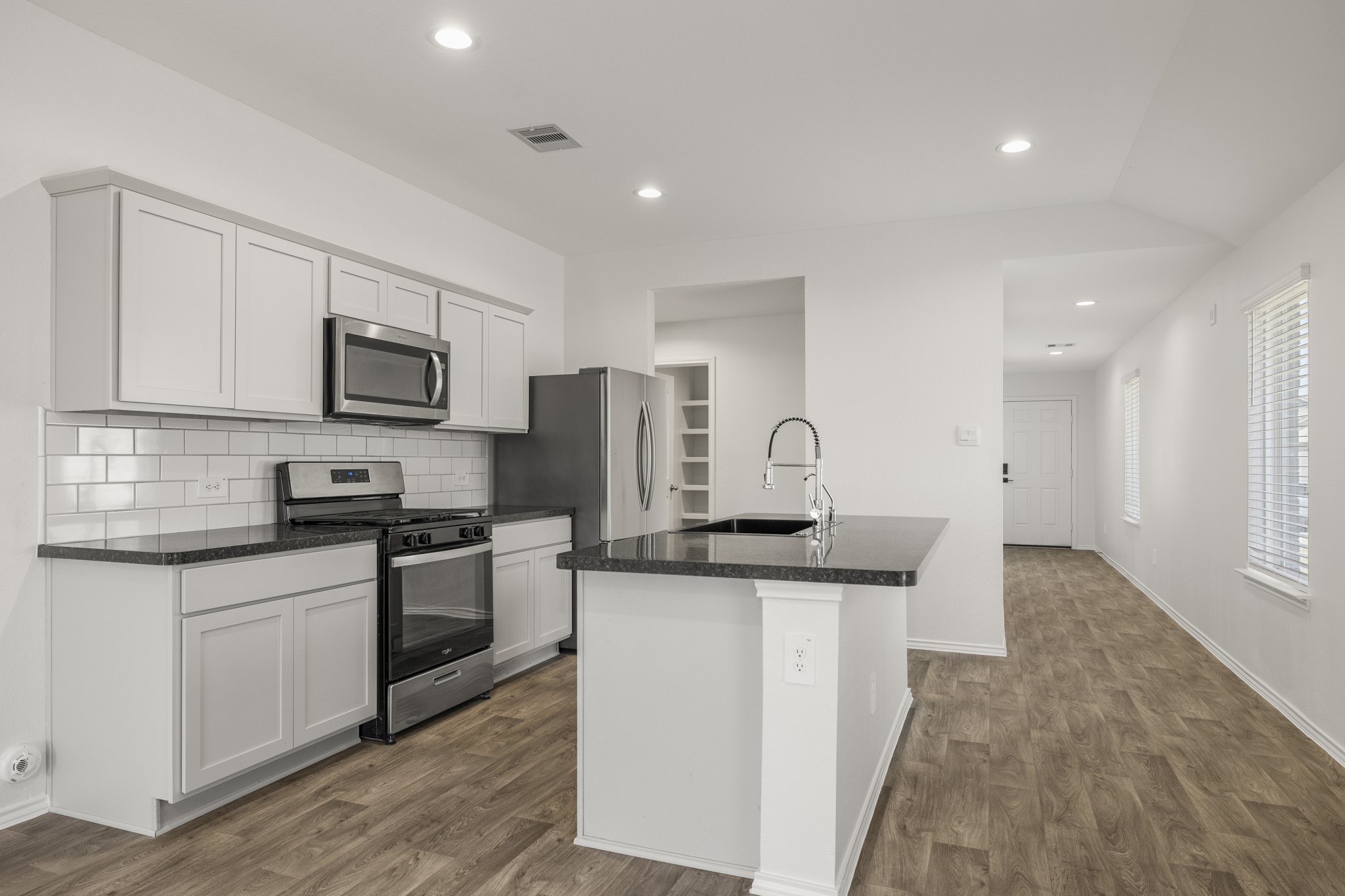 5402 Auburn Gardens Court Spring, TX 77373 - Photo 7 of 31 a kitchen with stainless steel appliances granite countertop a stove top oven a sink a refrigerator and white cabinets with wooden floor