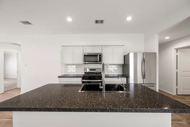 a kitchen with a sink stainless steel appliances and cabinets