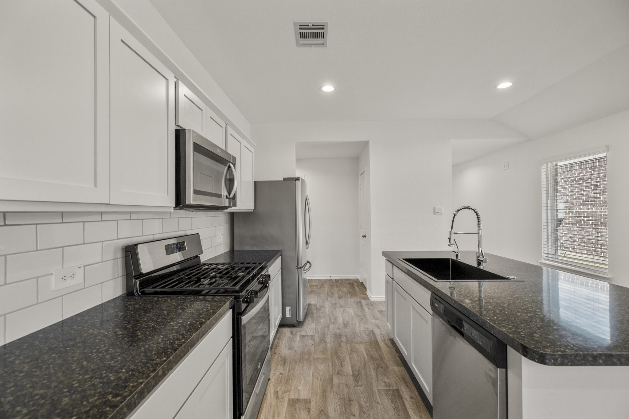 5402 Auburn Gardens Court Spring, TX 77373 - Photo 10 of 31 a kitchen with granite countertop a sink stainless steel appliances and cabinets