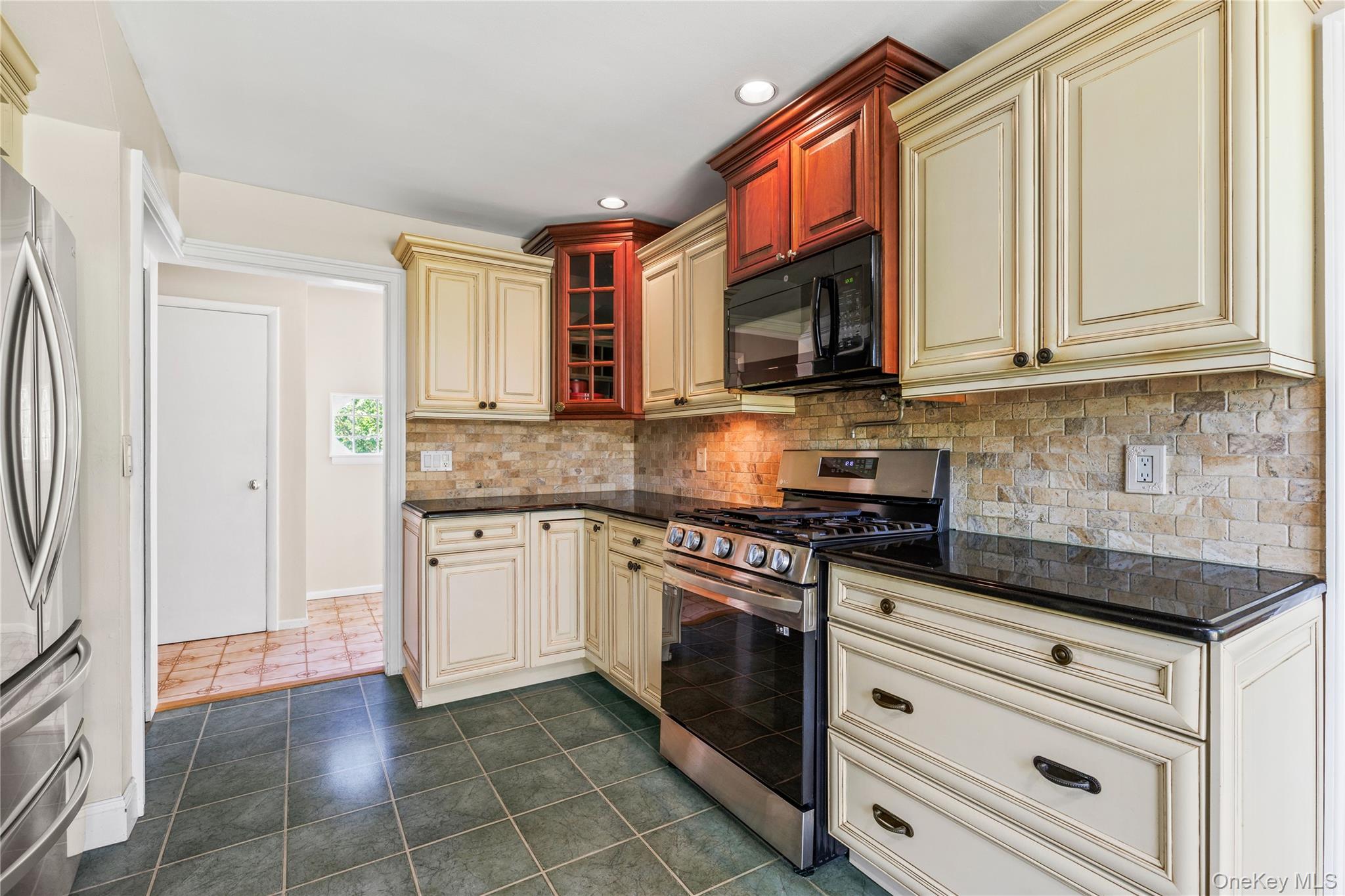 4 Mark Drive Rye Brook, NY 10573 - Photo 12 of 47 Kitchen with cream cabinets, appliances with stainless steel finishes, tasteful backsplash, dark tile patterned flooring, and recessed lighting