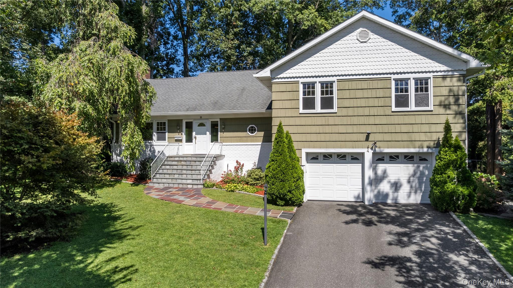 4 Mark Drive Rye Brook, NY 10573 - Photo 2 of 47 Split level home featuring driveway, a front lawn, a garage, and a shingled roof