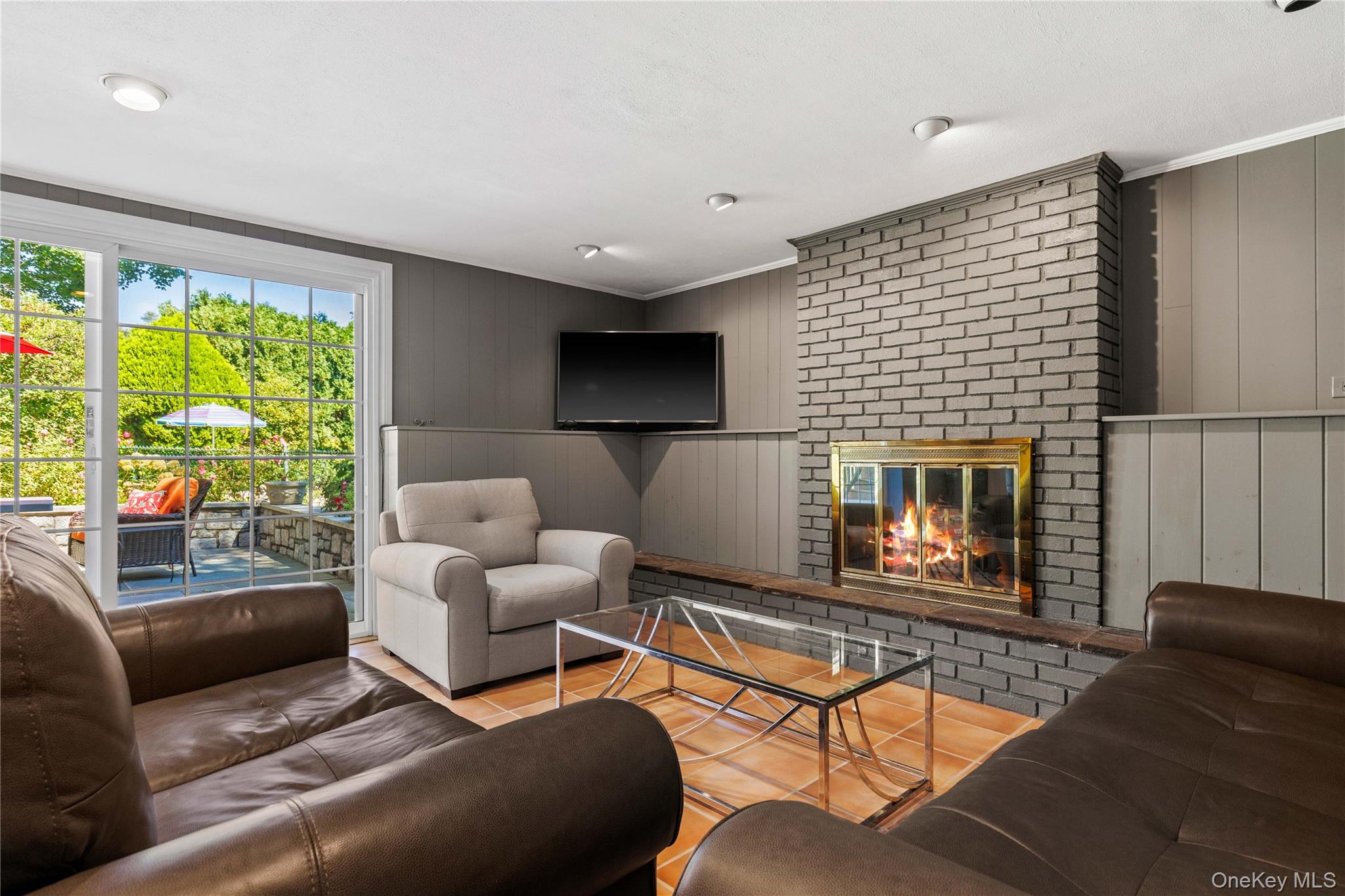 4 Mark Drive Rye Brook, NY 10573 - Photo 27 of 47 Living room with ornamental molding, a fireplace, wooden walls, and tile patterned floors