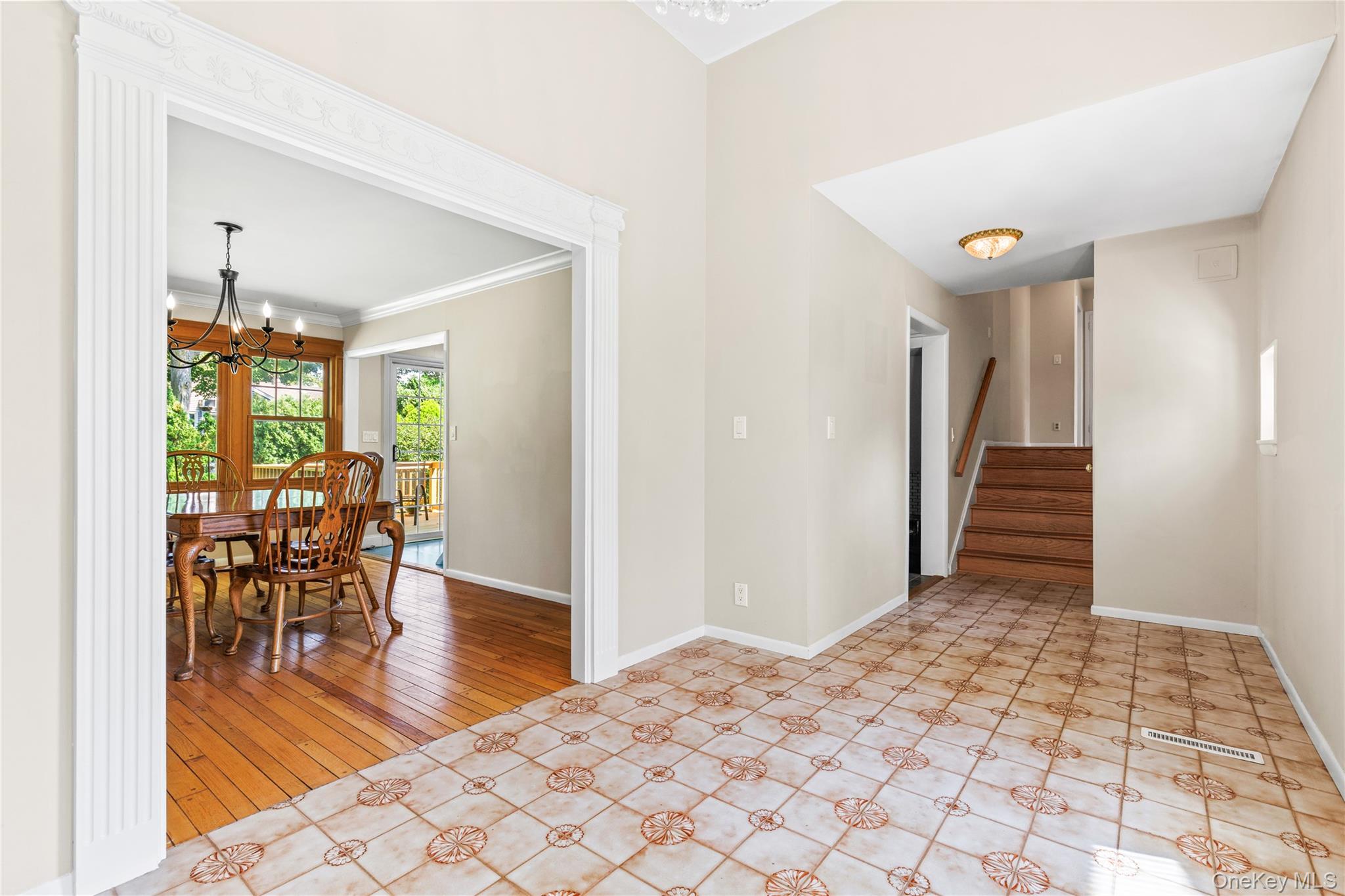 4 Mark Drive Rye Brook, NY 10573 - Photo 4 of 47 Empty room with a chandelier, stairway, light tile patterned floors, and crown molding