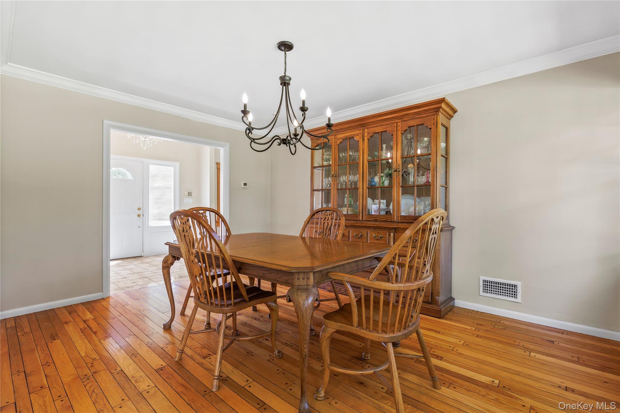 4 Mark Drive Rye Brook, NY 10573 - Photo 10 of 47 Dining area featuring crown molding, a chandelier, and light wood-style flooring