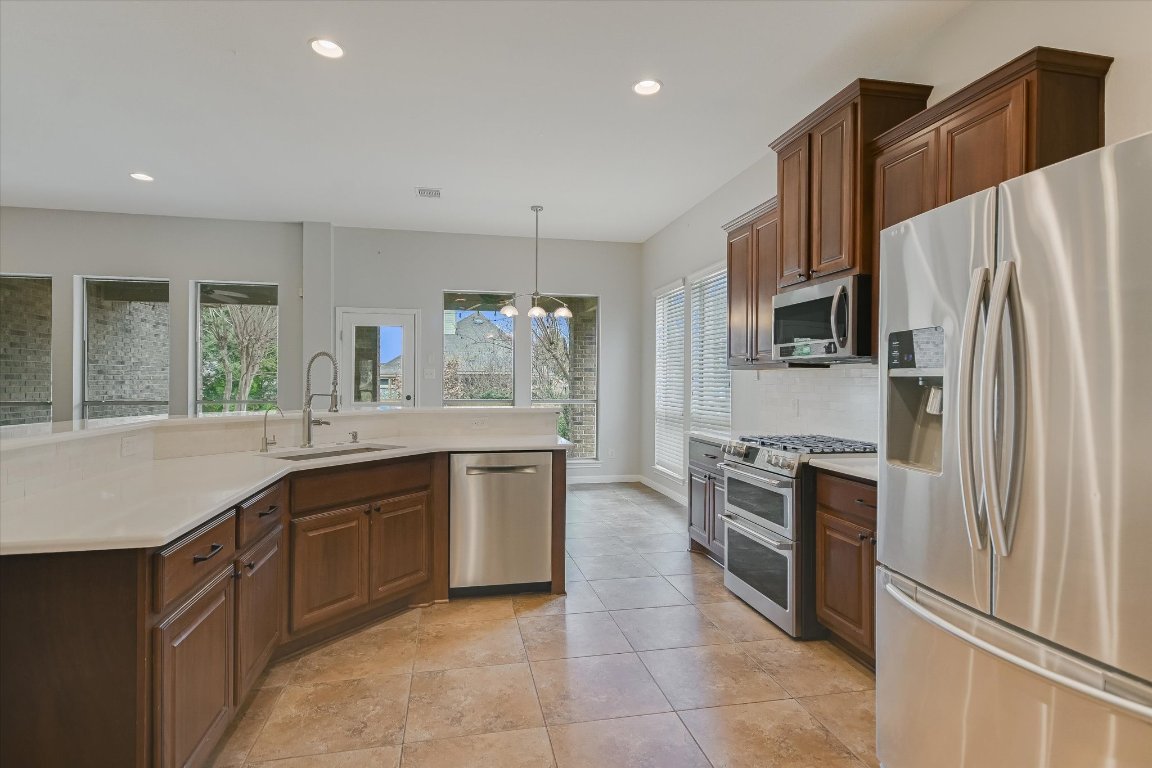 1911 Misty Ridge Leander, TX 78641 - Photo 8 of 30 a large kitchen with stainless steel appliances granite countertop a refrigerator and a sink