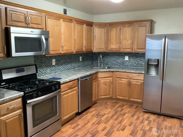 a kitchen with granite countertop a sink a stove and cabinets