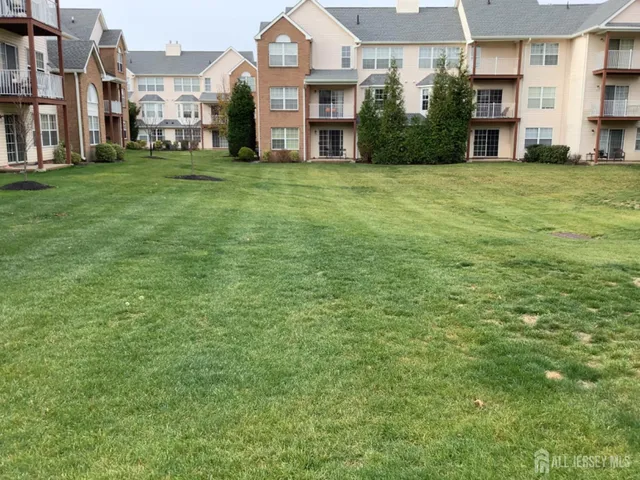 a view of a big house with a big yard and large trees