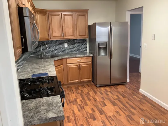 a kitchen with stainless steel appliances granite countertop a refrigerator and a stove