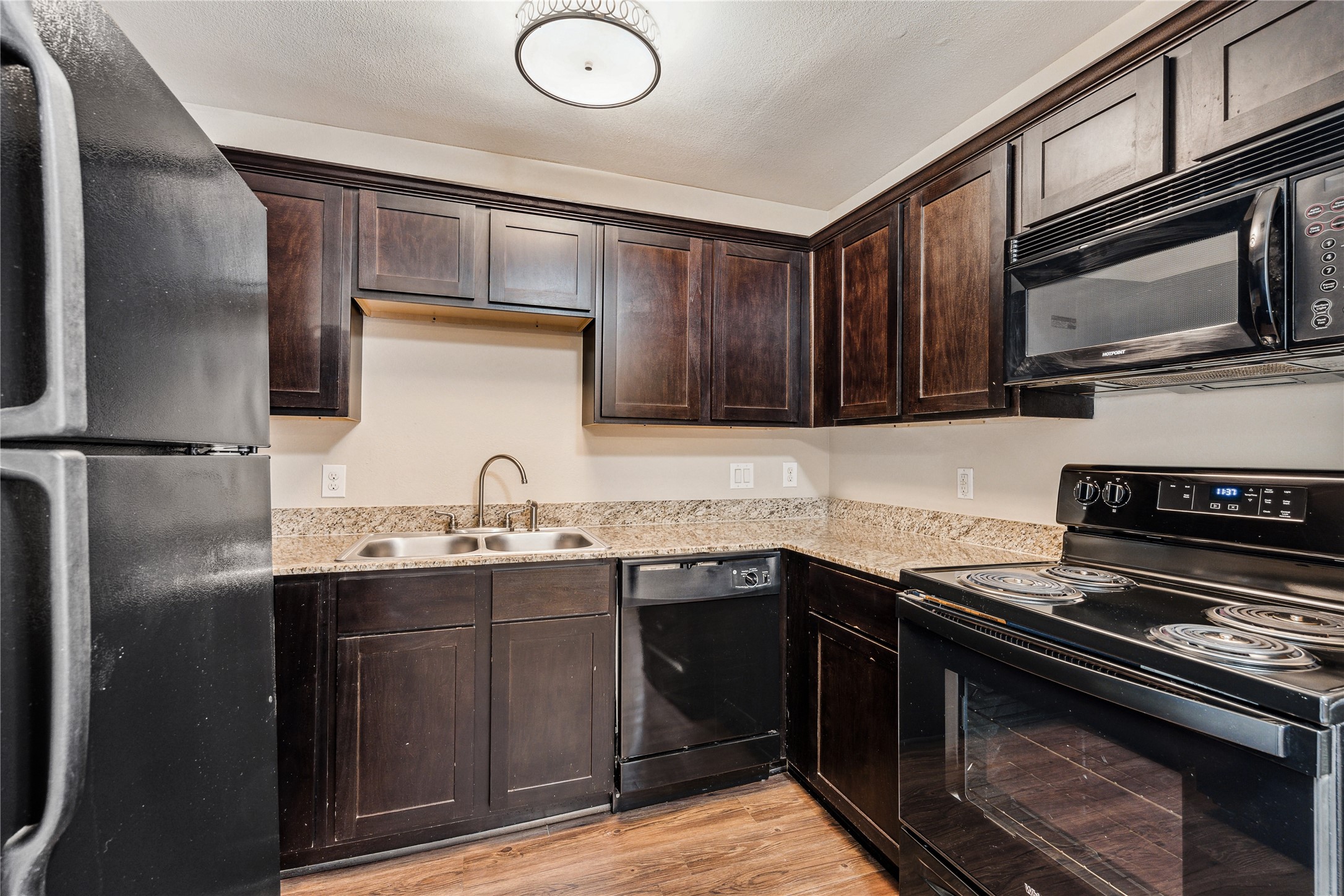 427 West 16th Street, Unit 2 Houston, TX 77008 - Photo 2 of 7 a kitchen with stainless steel appliances granite countertop a sink stove and microwave
