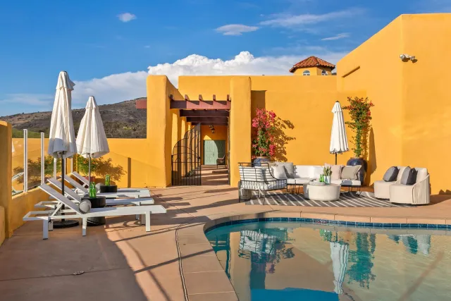 a view of a patio with a table and chairs under an umbrella with potted plants