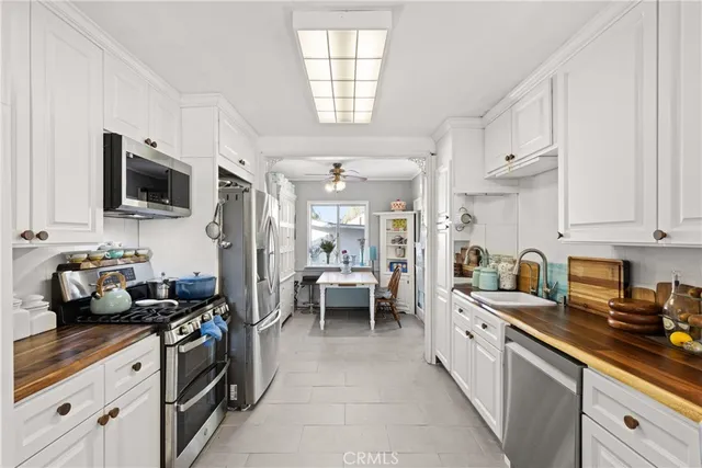a kitchen with kitchen island granite countertop a sink appliances cabinets and a counter top space