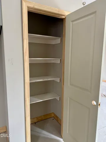 a view of walk in closet with empty racks