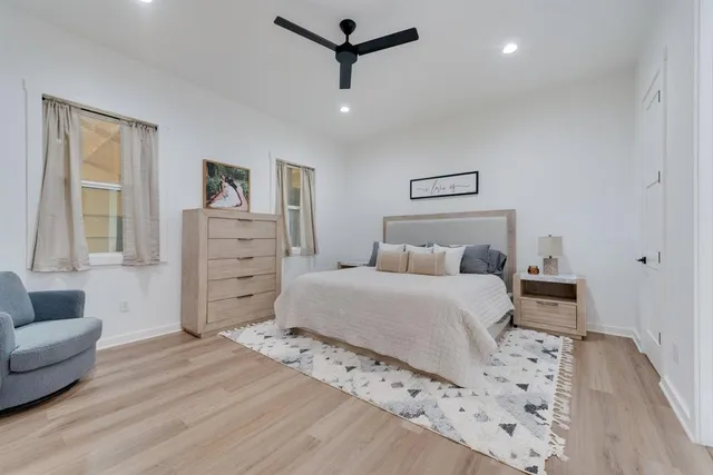 a bedroom with a bed a couch and a flat screen tv