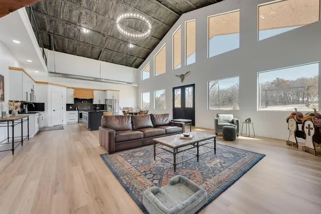 a kitchen with stainless steel appliances a stove a sink dishwasher a refrigerator with white cabinets and wooden floor