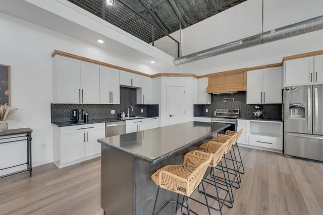 a dining room with stainless steel appliances kitchen island granite countertop a dining table chairs and view living room