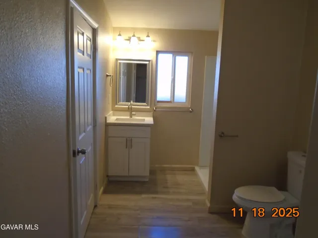 a bathroom with a toilet sink a mirror and vanity