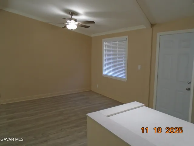 a workspace with wooden floor a chandelier fan and windows