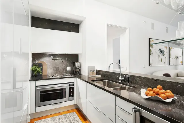 a kitchen with stainless steel appliances a stove a sink and cabinets