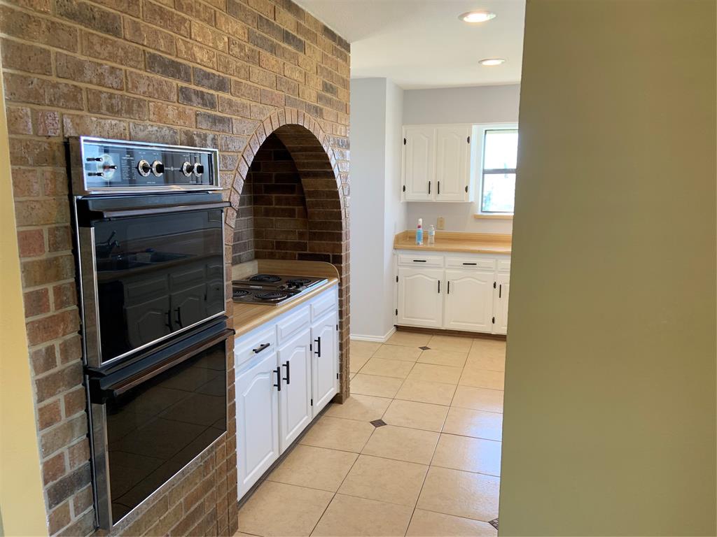 781 January Lane Ponder, TX 76259 - Photo 17 of 25 a kitchen with cabinets and a stove top oven