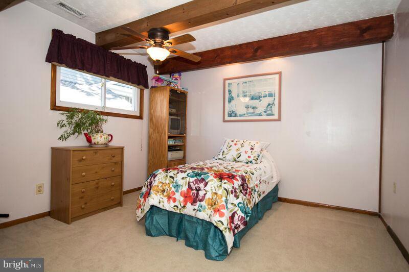 1929 Wilson Point Road Baltimore, MD 21220 - Photo 15 of 30 a bedroom with a bed and a chandelier