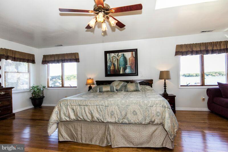 1929 Wilson Point Road Baltimore, MD 21220 - Photo 22 of 30 a bedroom with a large bed and wooden floor
