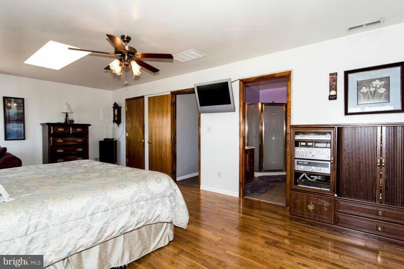 1929 Wilson Point Road Baltimore, MD 21220 - Photo 23 of 30 a spacious bedroom with a bed and a flat screen tv