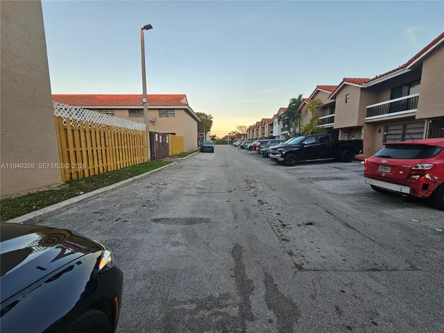 a view of city street with a parked cars side of road and a building