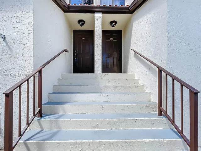 a view of a kitchen with kitchen island a counter top space appliances and a ceiling fan