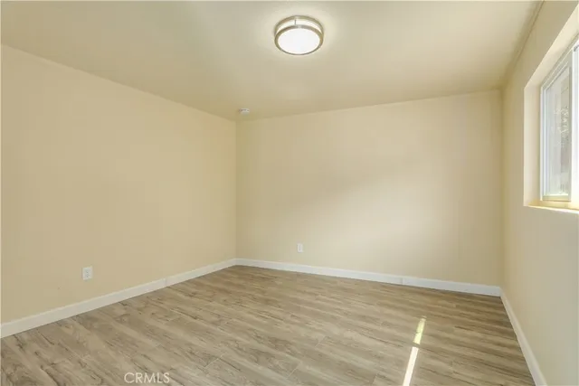 a view of a room with wooden floor and window