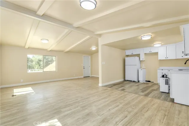 a view of empty room with wooden floor and window