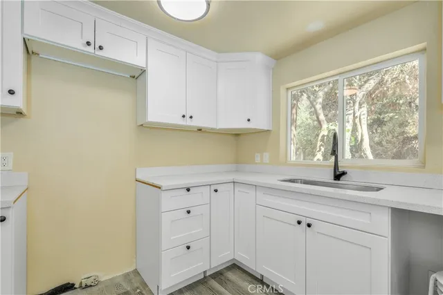 a kitchen with white cabinets and a window