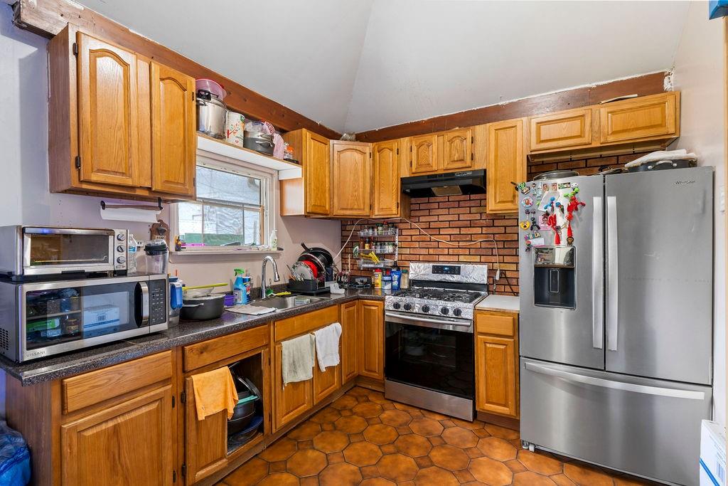 32 Brighton 2nd Place Brooklyn, NY 11235 - Photo 14 of 23 a kitchen with stainless steel appliances granite countertop a stove sink and refrigerator