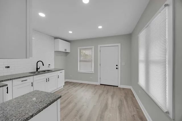 a large kitchen with a sink and natural light