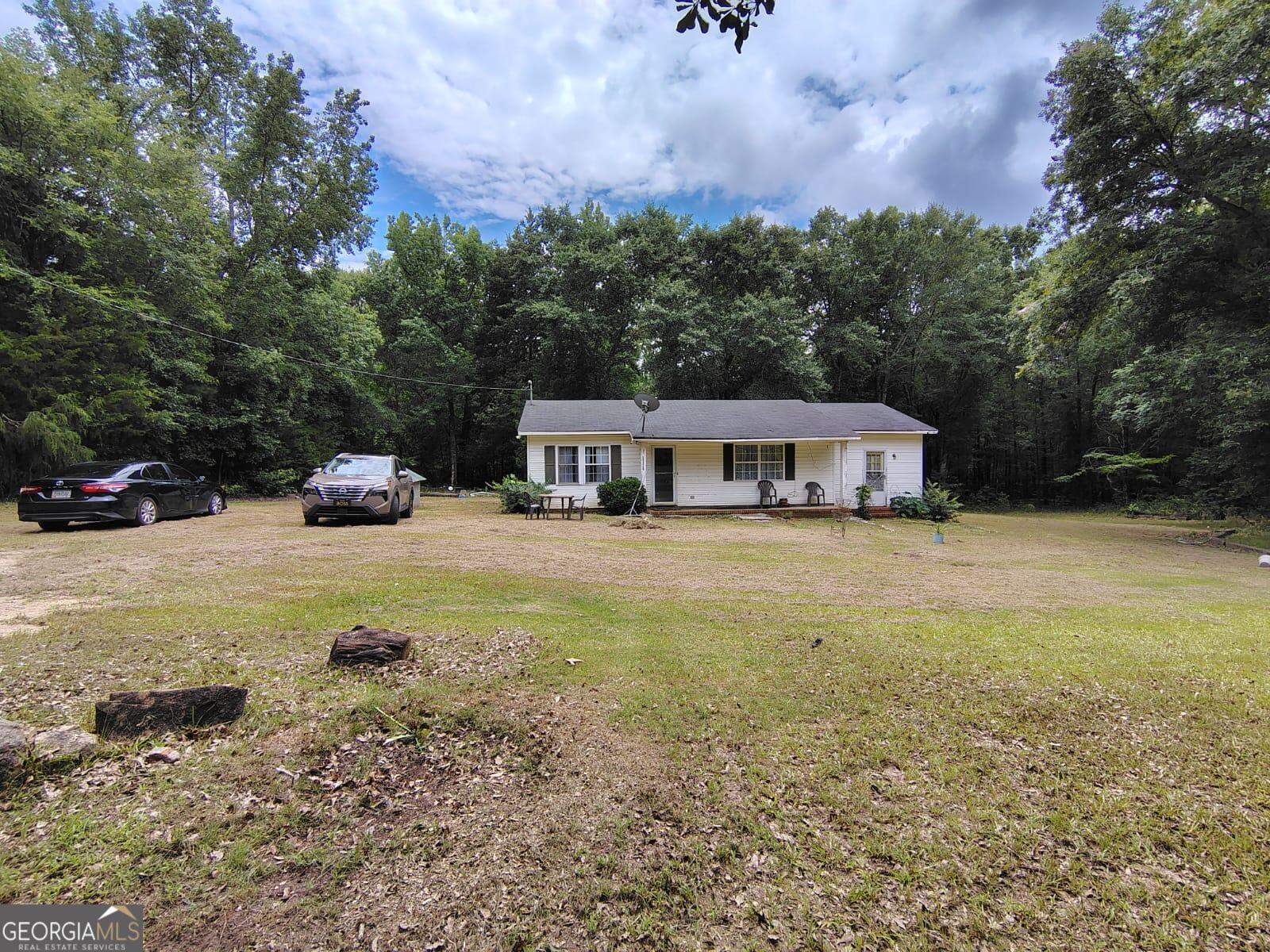 5576 Po Biddy Road Talbotton, GA 31827 - Photo 1 of 28 a yellow and red house sitting in the middle of a field