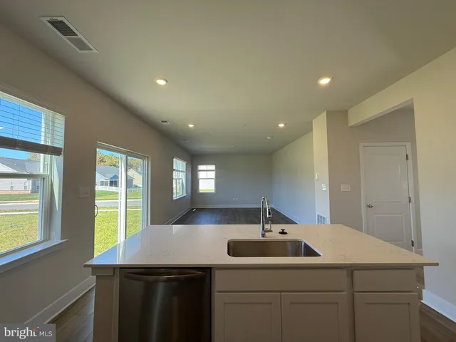 a kitchen with kitchen island a counter top space cabinets stainless steel appliances and a window