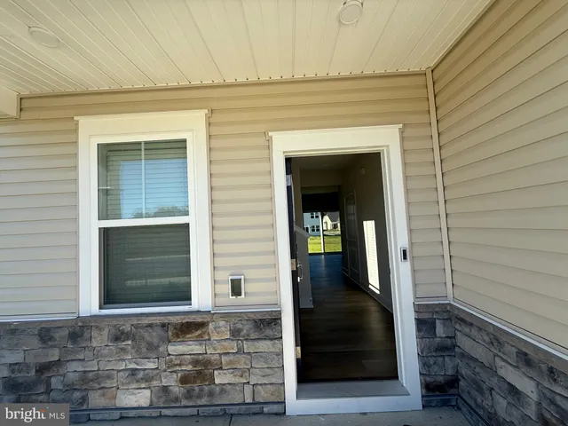 a view of a hallway with wooden floor and stairs