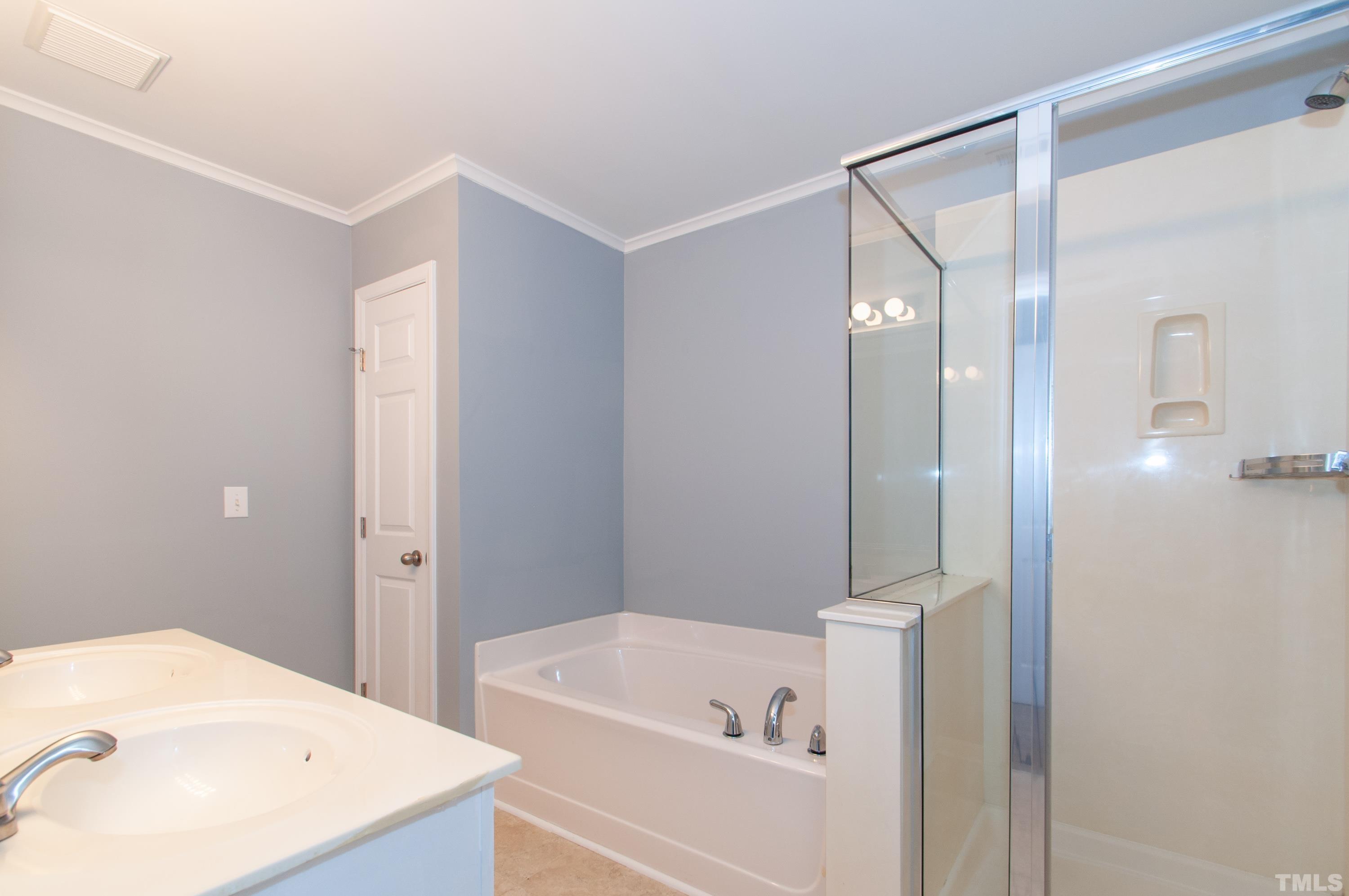 2210 Raven Road, Unit 102 Raleigh, NC 27614 - Photo 14 of 33 a bathroom with a tub a sink and a large mirror
