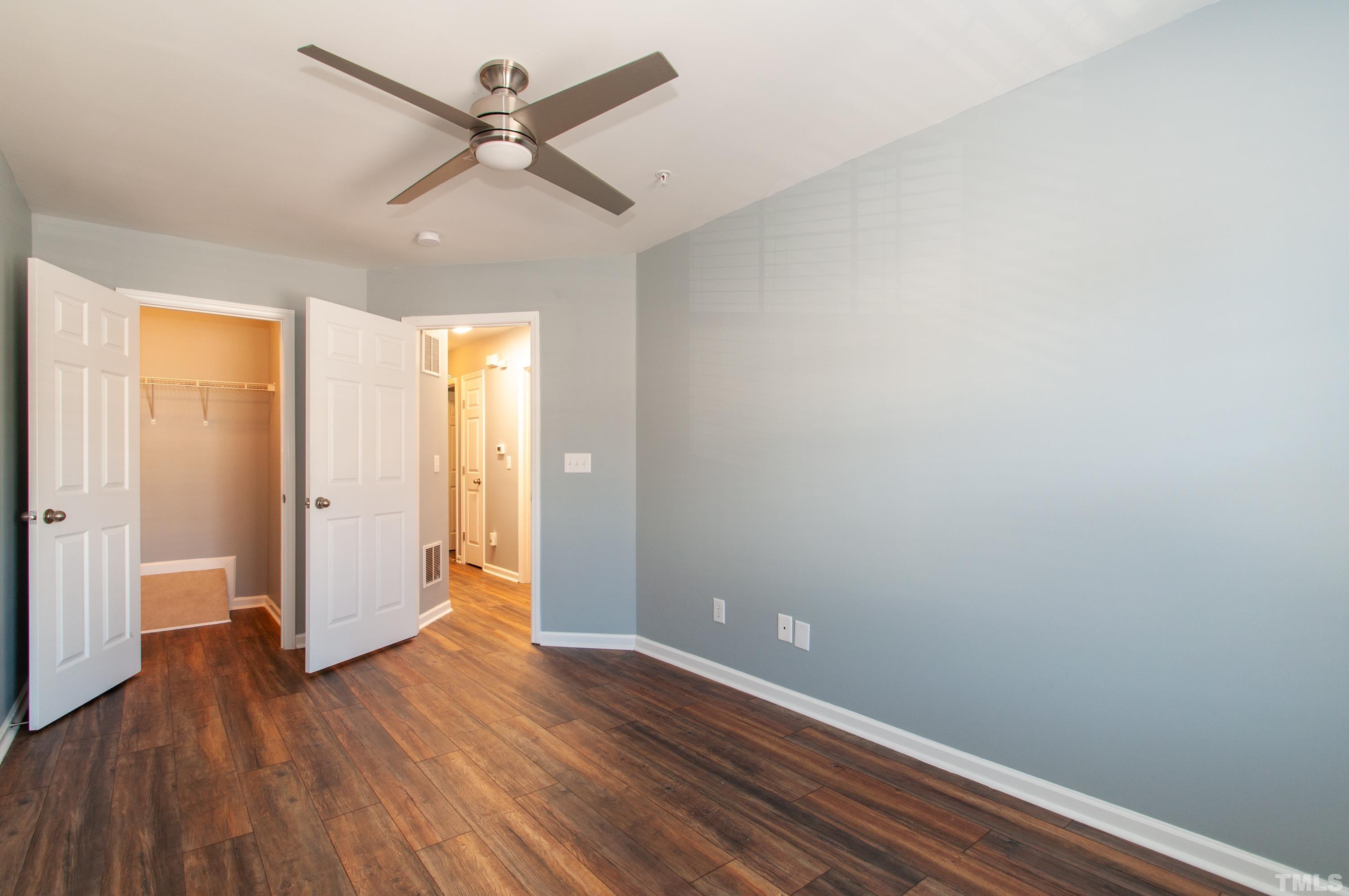 2210 Raven Road, Unit 102 Raleigh, NC 27614 - Photo 17 of 33 an empty room with wooden floor and a ceiling fan