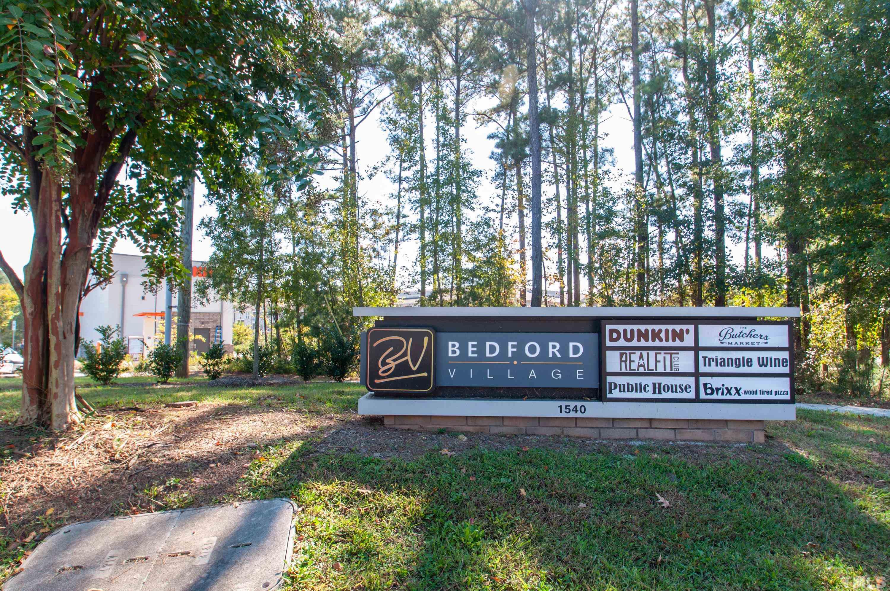 2210 Raven Road, Unit 102 Raleigh, NC 27614 - Photo 28 of 33 a view of a park that has a bench and trees with wooden fence