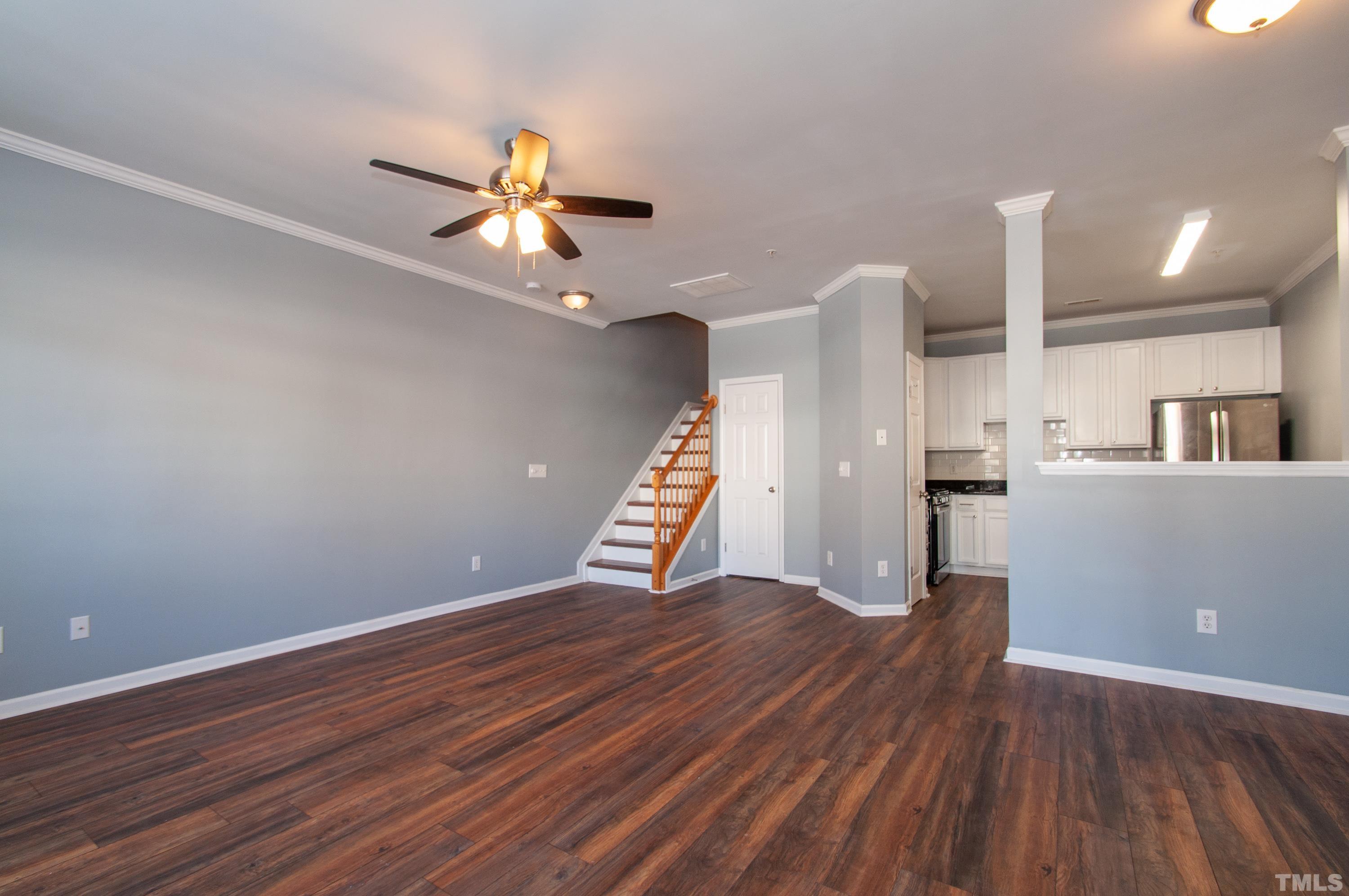 2210 Raven Road, Unit 102 Raleigh, NC 27614 - Photo 3 of 33 a view of an empty room with wooden floor and a ceiling fan