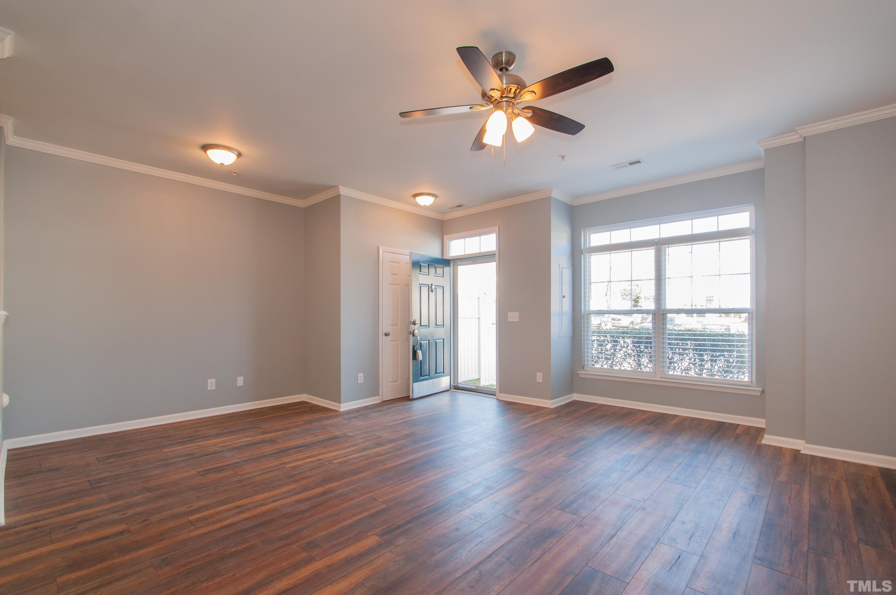 2210 Raven Road, Unit 102 Raleigh, NC 27614 - Photo 5 of 33 a view of an empty room with wooden floor and a window