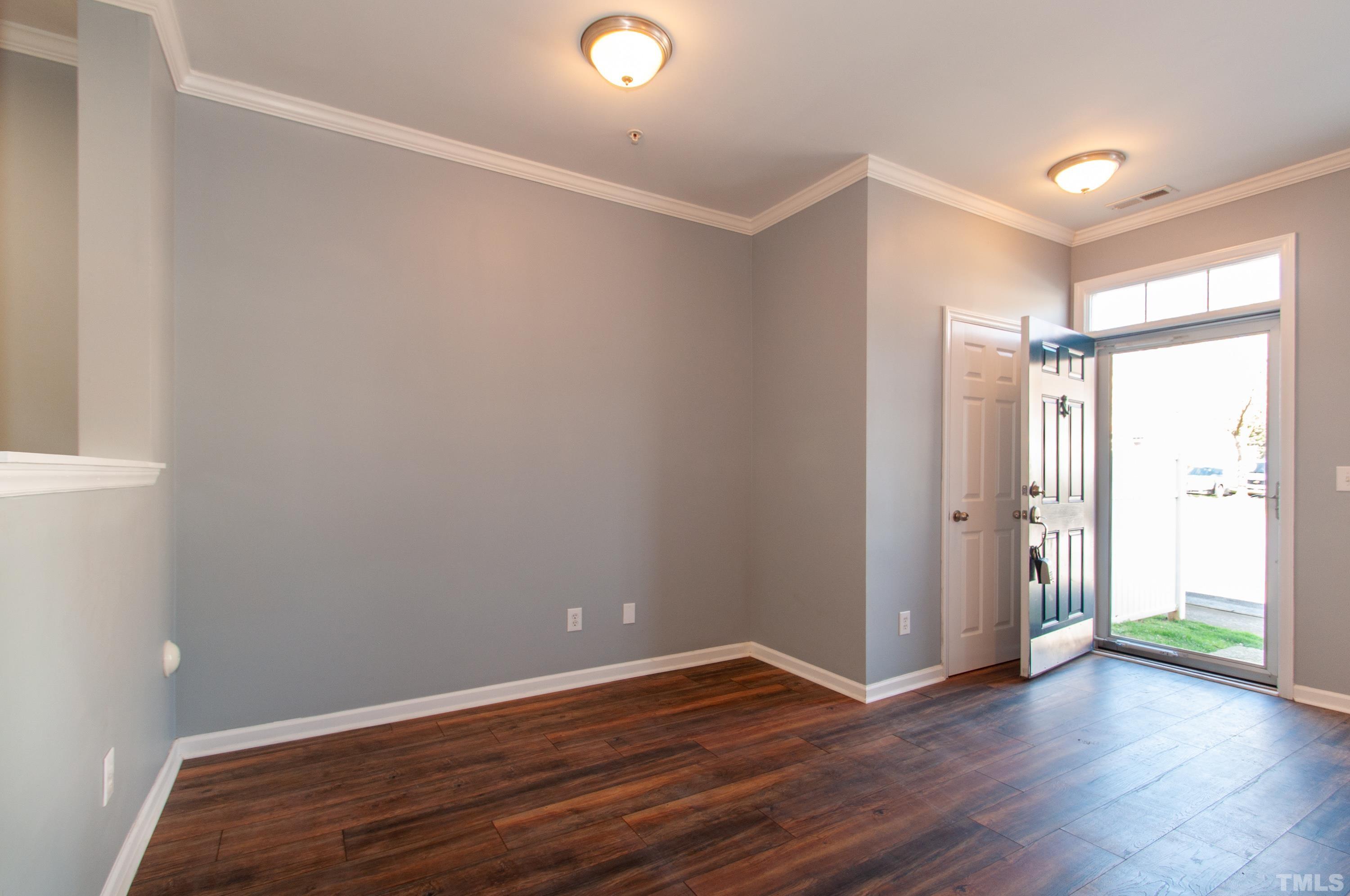 2210 Raven Road, Unit 102 Raleigh, NC 27614 - Photo 6 of 33 a view of an empty room with wooden floor and a window