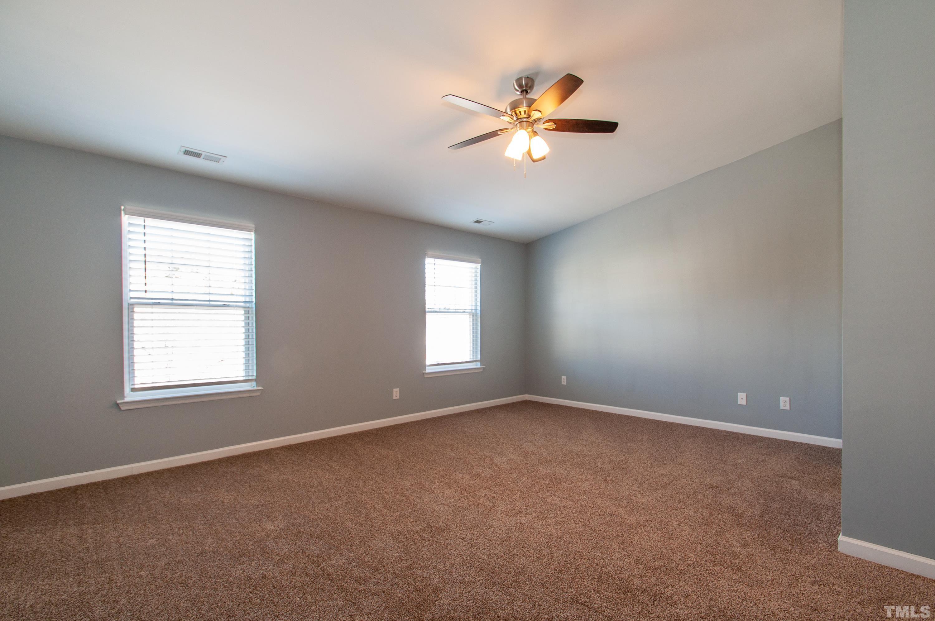 2210 Raven Road, Unit 102 Raleigh, NC 27614 - Photo 10 of 33 an empty room with windows and chandelier fan