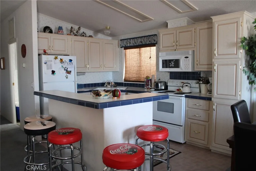 2 Havasu Lake Road Needles, CA 92363 - Photo 11 of 24 a kitchen with stainless steel appliances a sink cabinets and a refrigerator