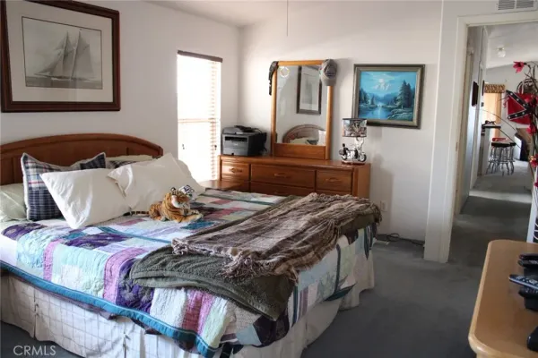 a bedroom with bed and wooden floor