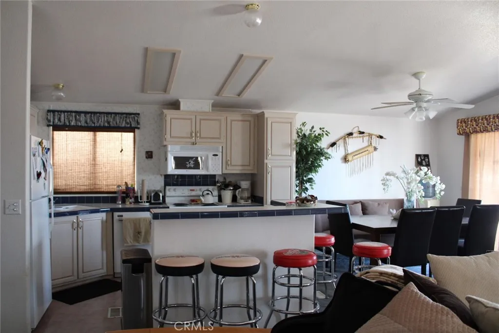 2 Havasu Lake Road Needles, CA 92363 - Photo 7 of 24 a kitchen with stainless steel appliances kitchen island granite countertop a table chairs in it and wooden floors