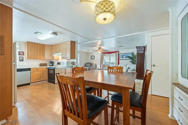 a dining room with stainless steel appliances kitchen island granite countertop a dining table chairs and a oven