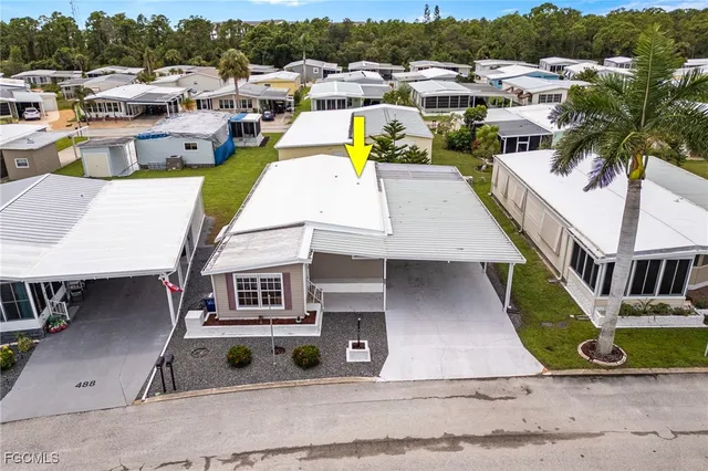 an aerial view of a house with swimming pool lawn chairs and large trees