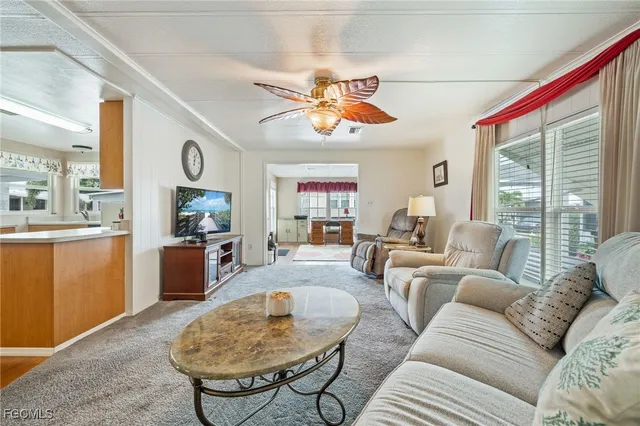a living room with furniture a fireplace and a large window