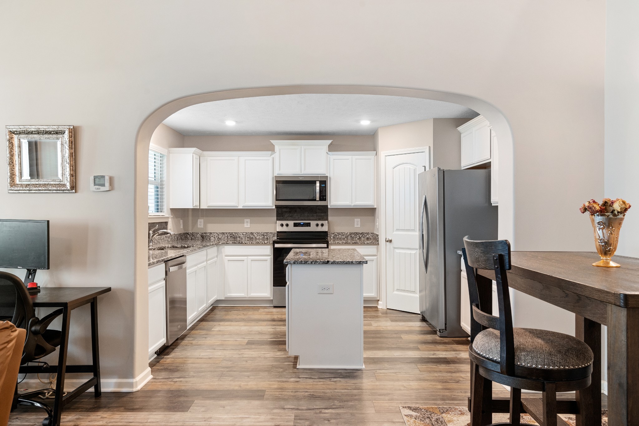 1626 Calcutta Drive Murfreesboro, TN 37128 - Photo 14 of 35 a kitchen with stainless steel appliances granite countertop a refrigerator a stove top oven a sink dishwasher and white cabinets with wooden floor